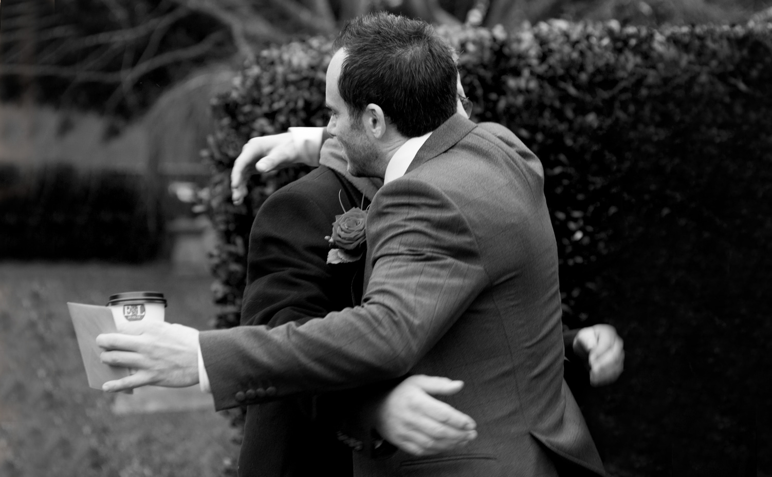 Groom hugging dad by Brighton documentary wedding photographer James Robertshaw