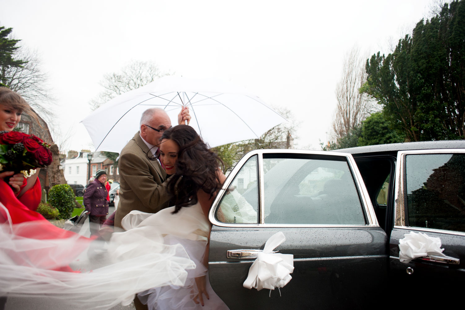 Bride alighting from wedding car by Brighton documentary wedding photographer James Robertshaw