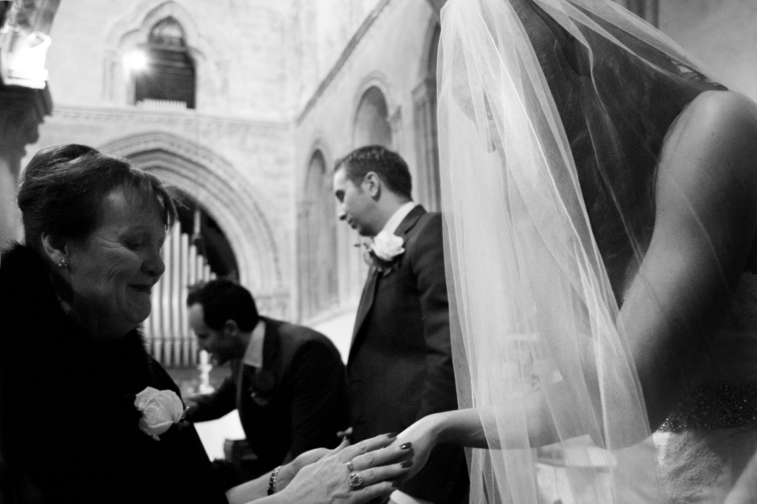 Mother in law coveting brides hand in church by Brighton documentary wedding photographer James Robertshaw