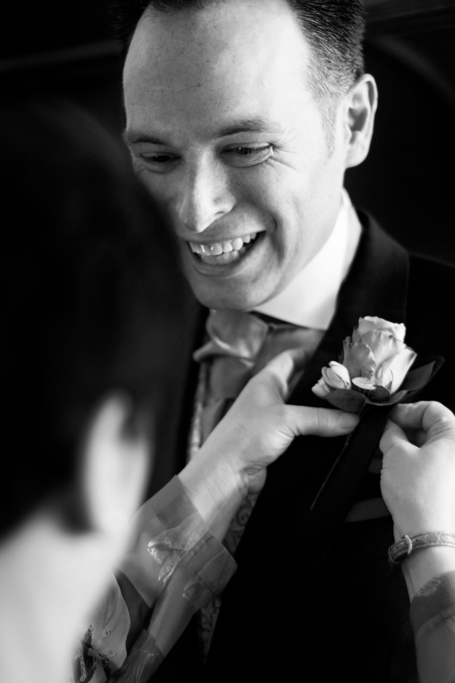 Guest fixing groom's buttonhole