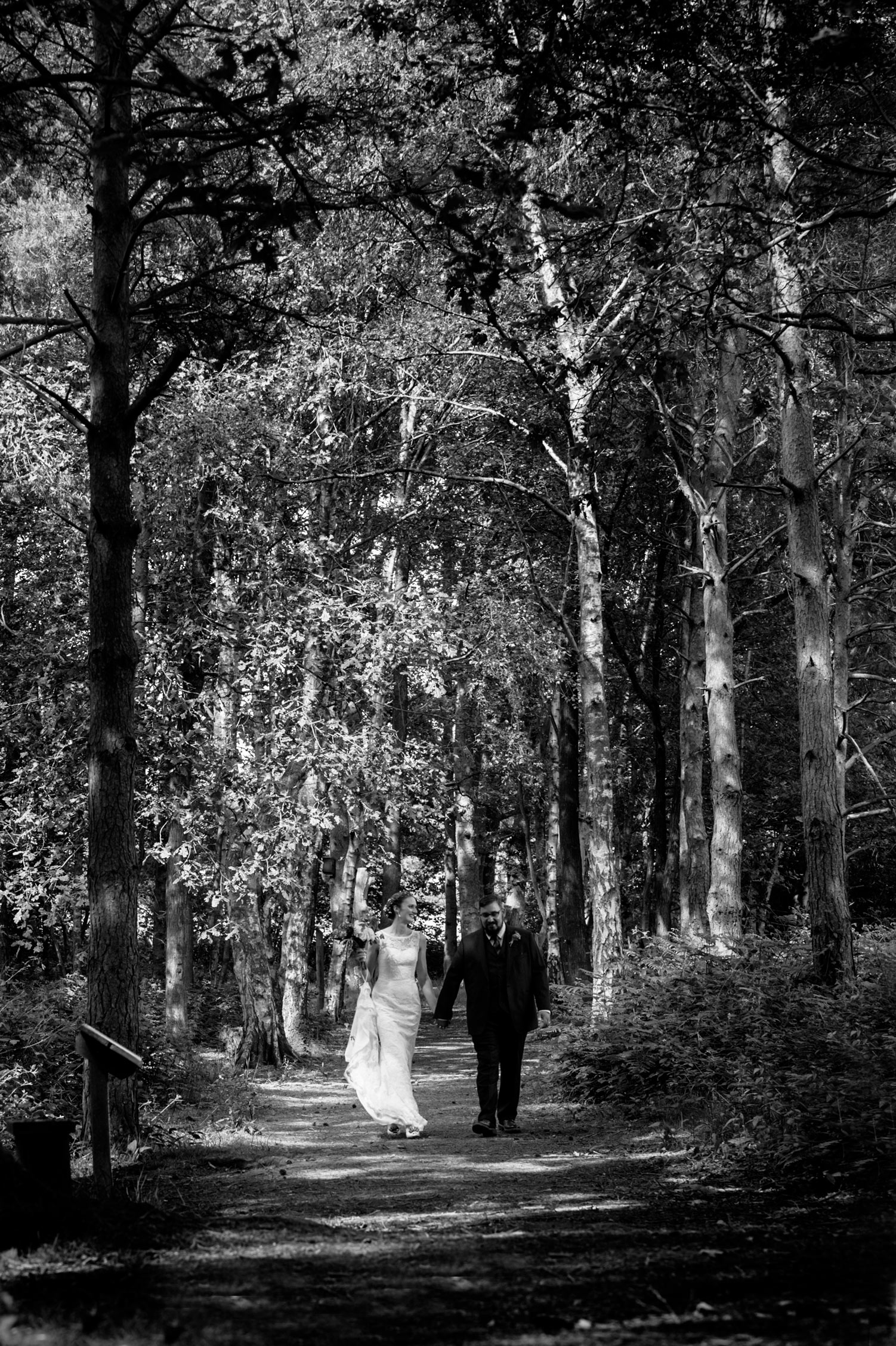 Newly married couple walking through woodland