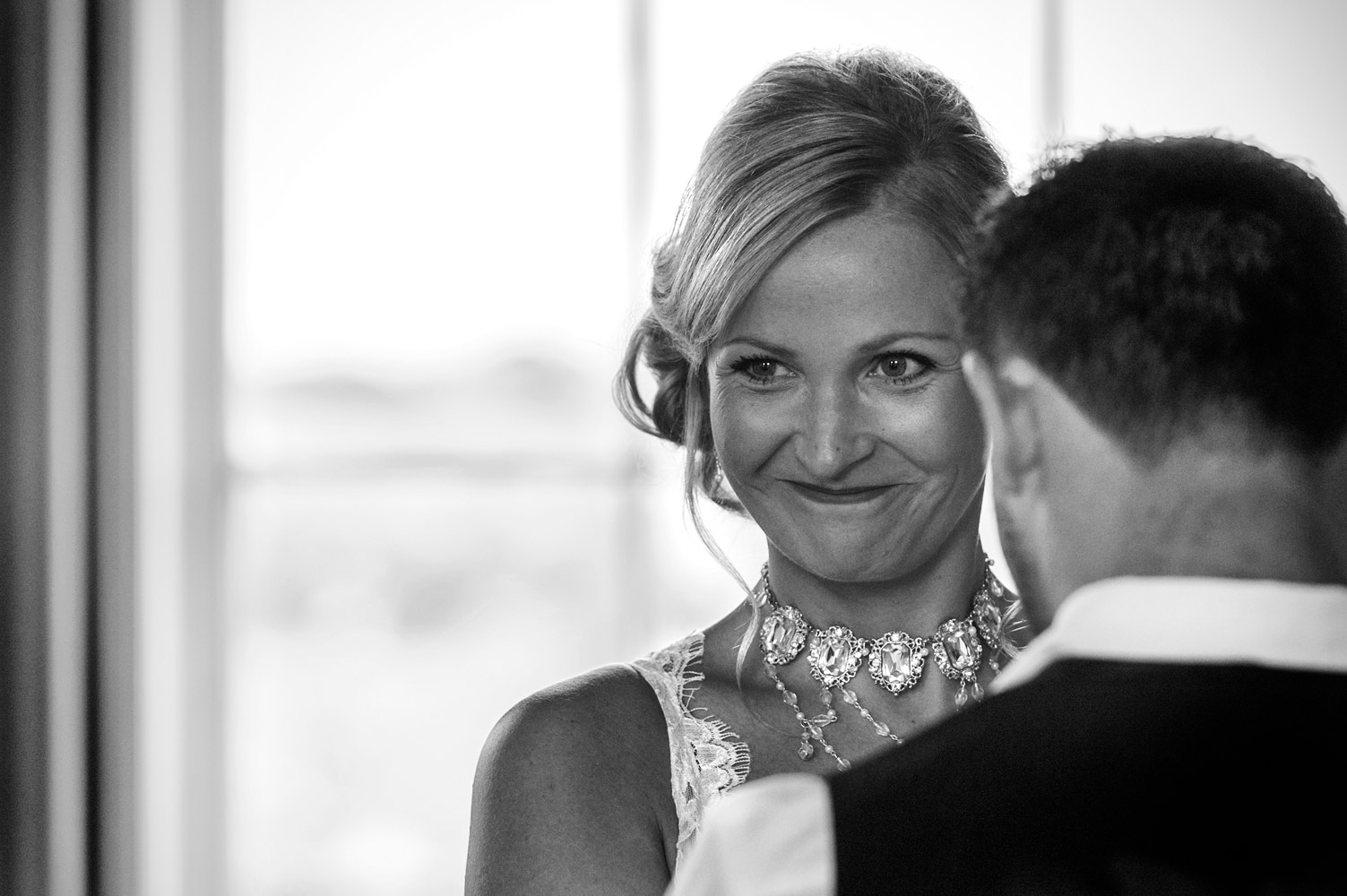 Proud bride smiling during cermeony by Sussex documentary wedding photographer James Robertshaw