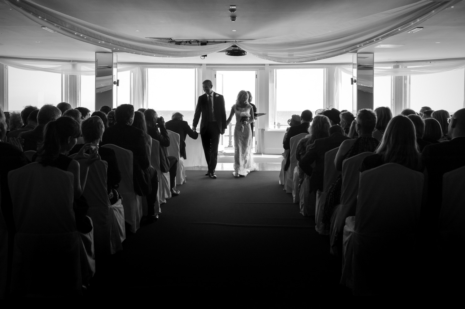 Guest shaking groom's hand after wedding ceremony