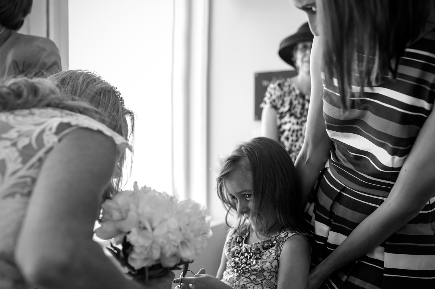 Shy girl talking to bride by informal Sussex wedding photographer James Robertshaw