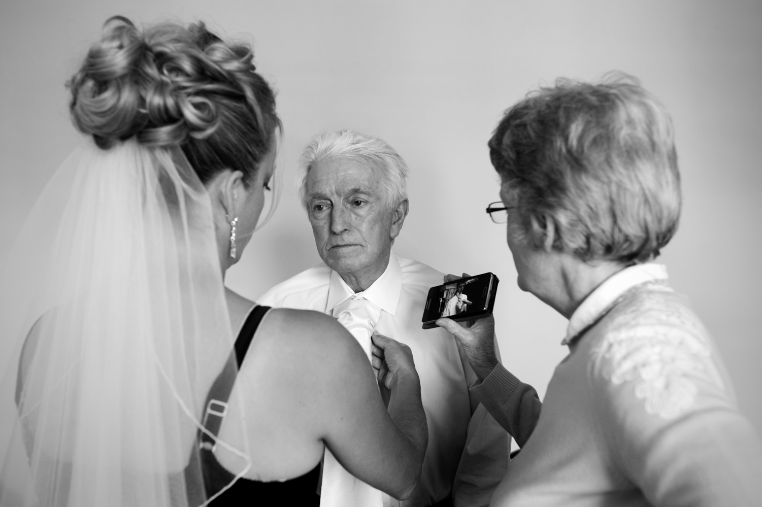 Bride tying fathers necktie