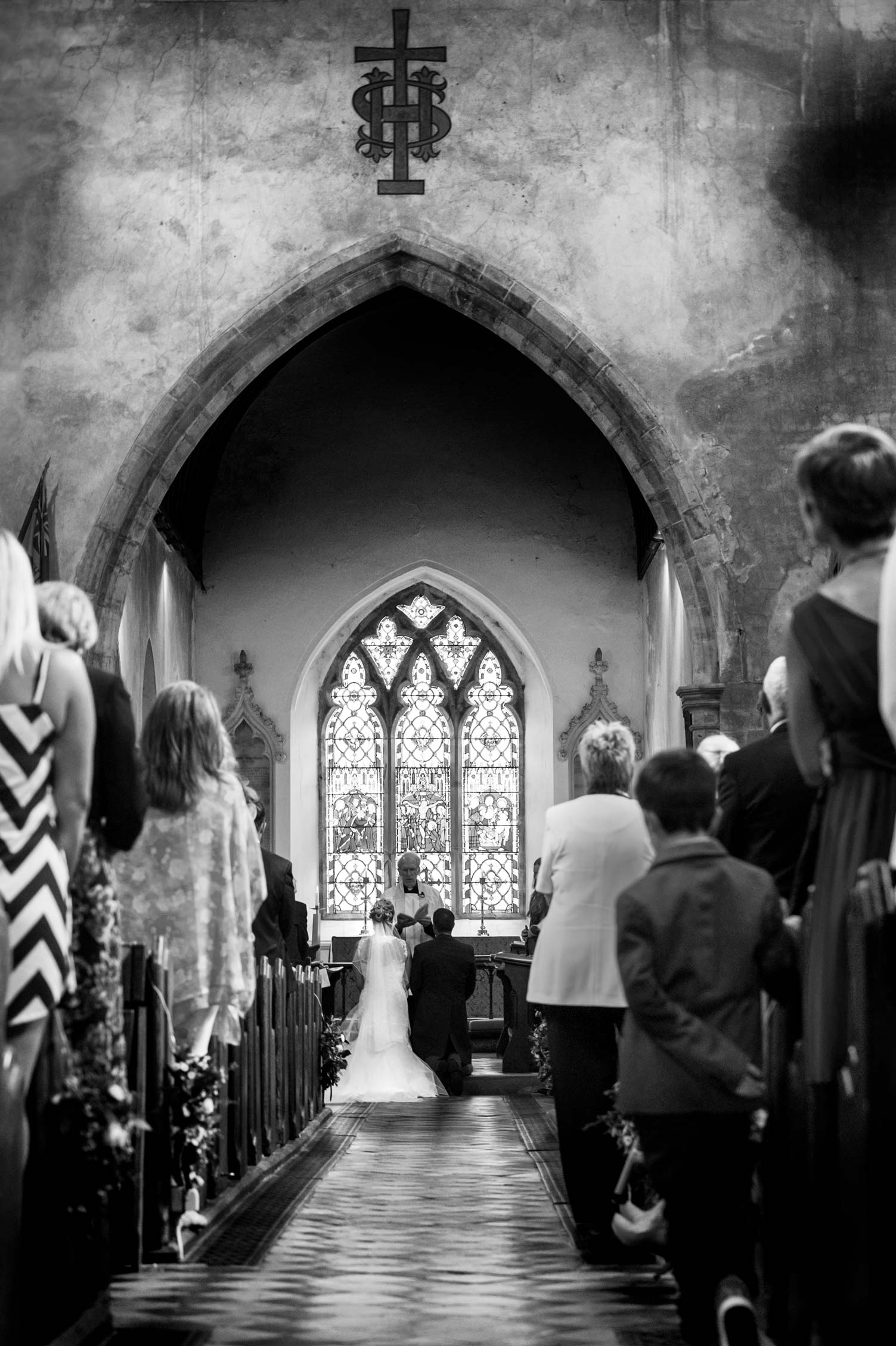 Bride and groom kneeling in church by Sussex documentary wedding photographer James Robertshaw