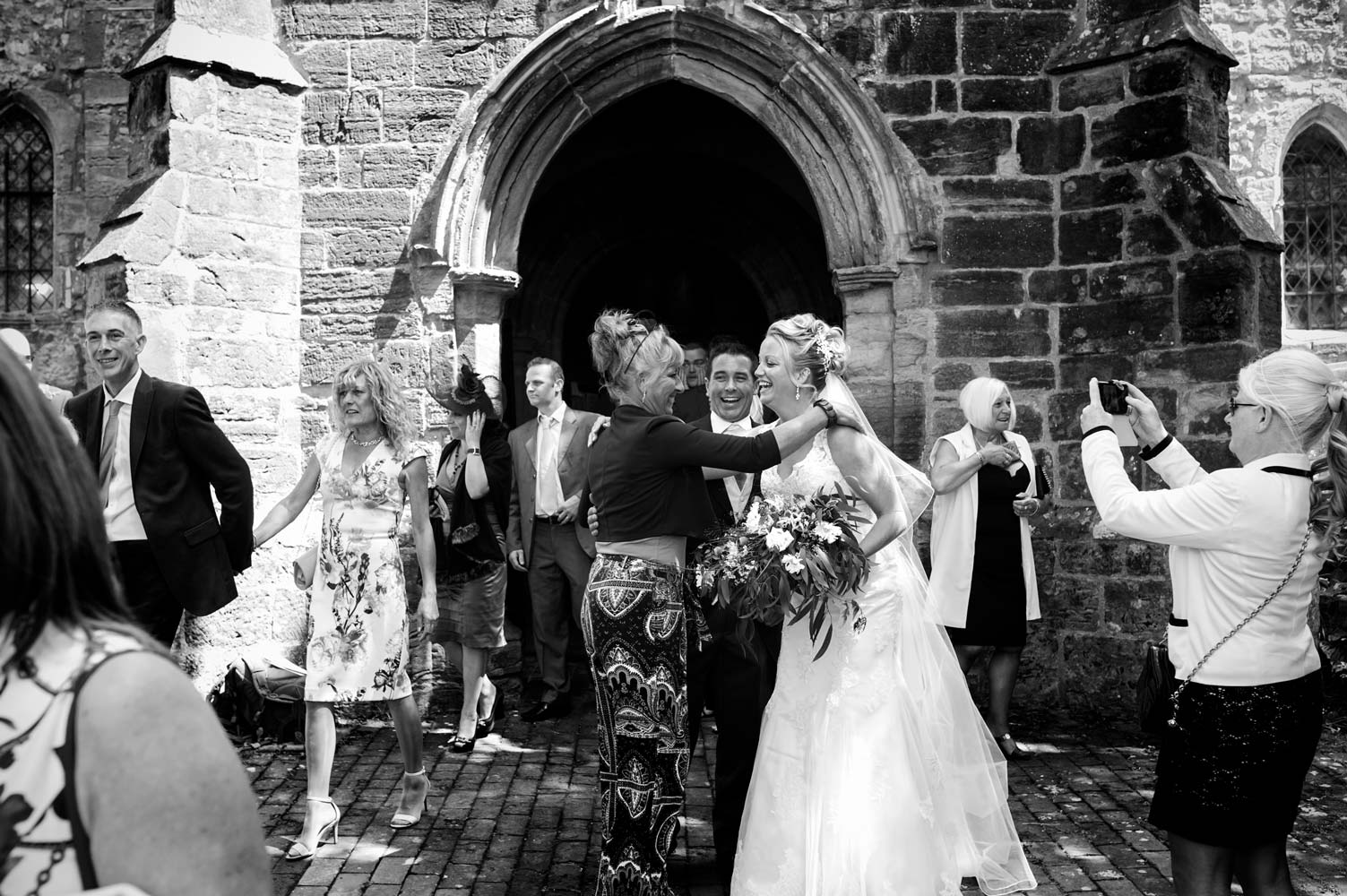 Guests congratulating couple outside church by Sussex documentary wedding photographer James Robertshaw 
