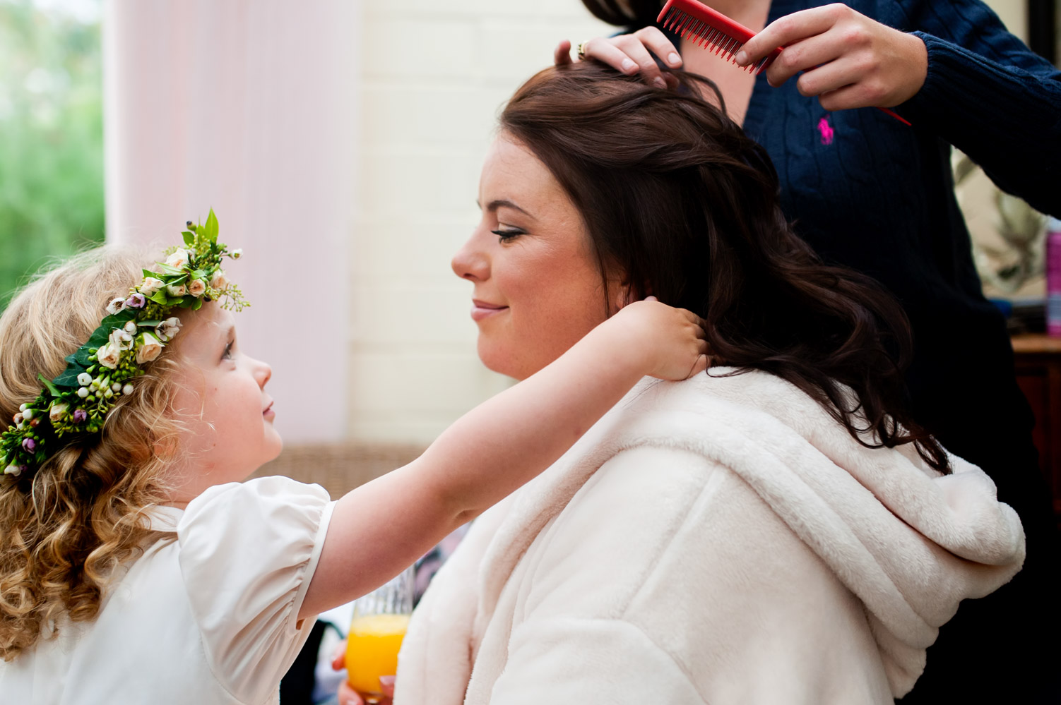 Child smiling at bride getting ready