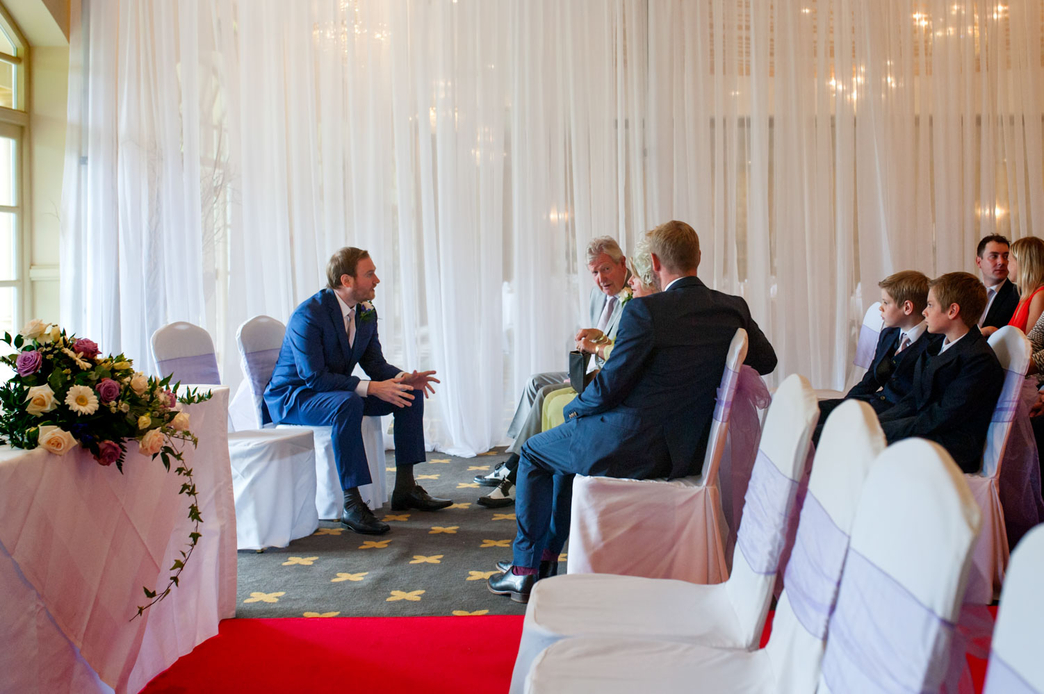 Groom chatting to family before ceremony