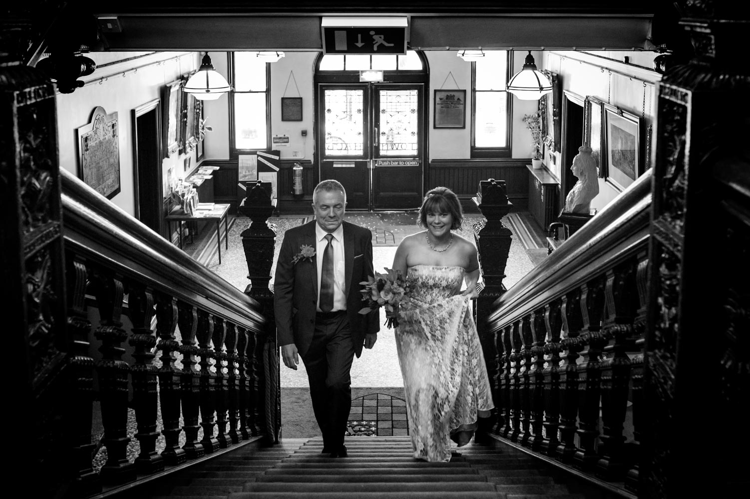 Bride and father walking up staircase in Lewes Town Hall