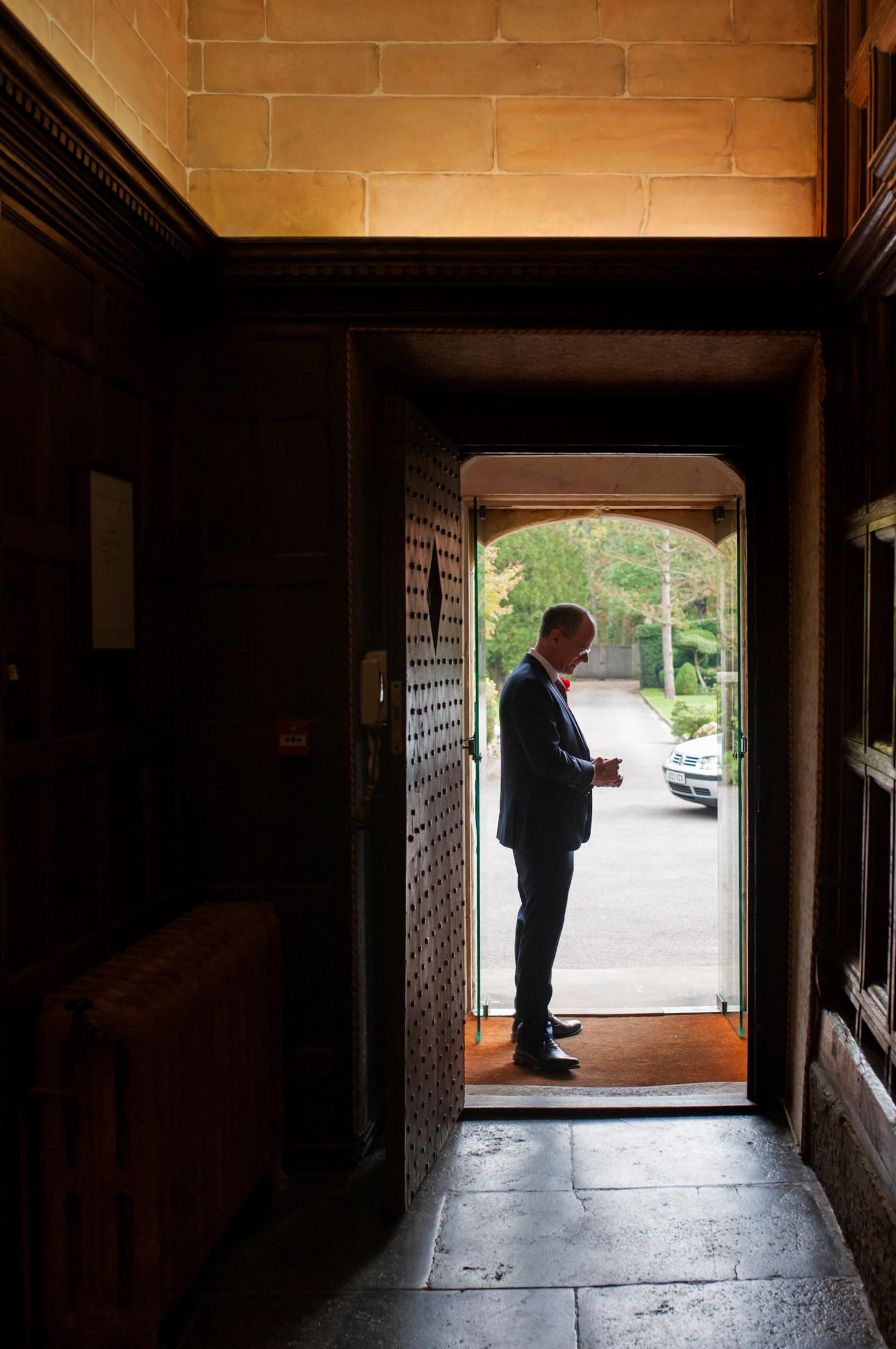 Groom in doorway at Smallfield Place wedding