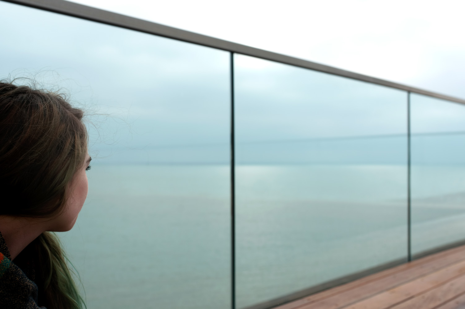 Young woman alone looking out to sea