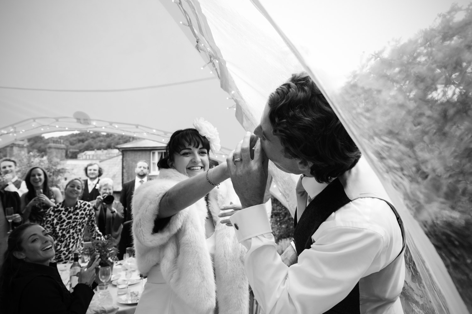 Bride stuffing wedding cake into the mouth of groom