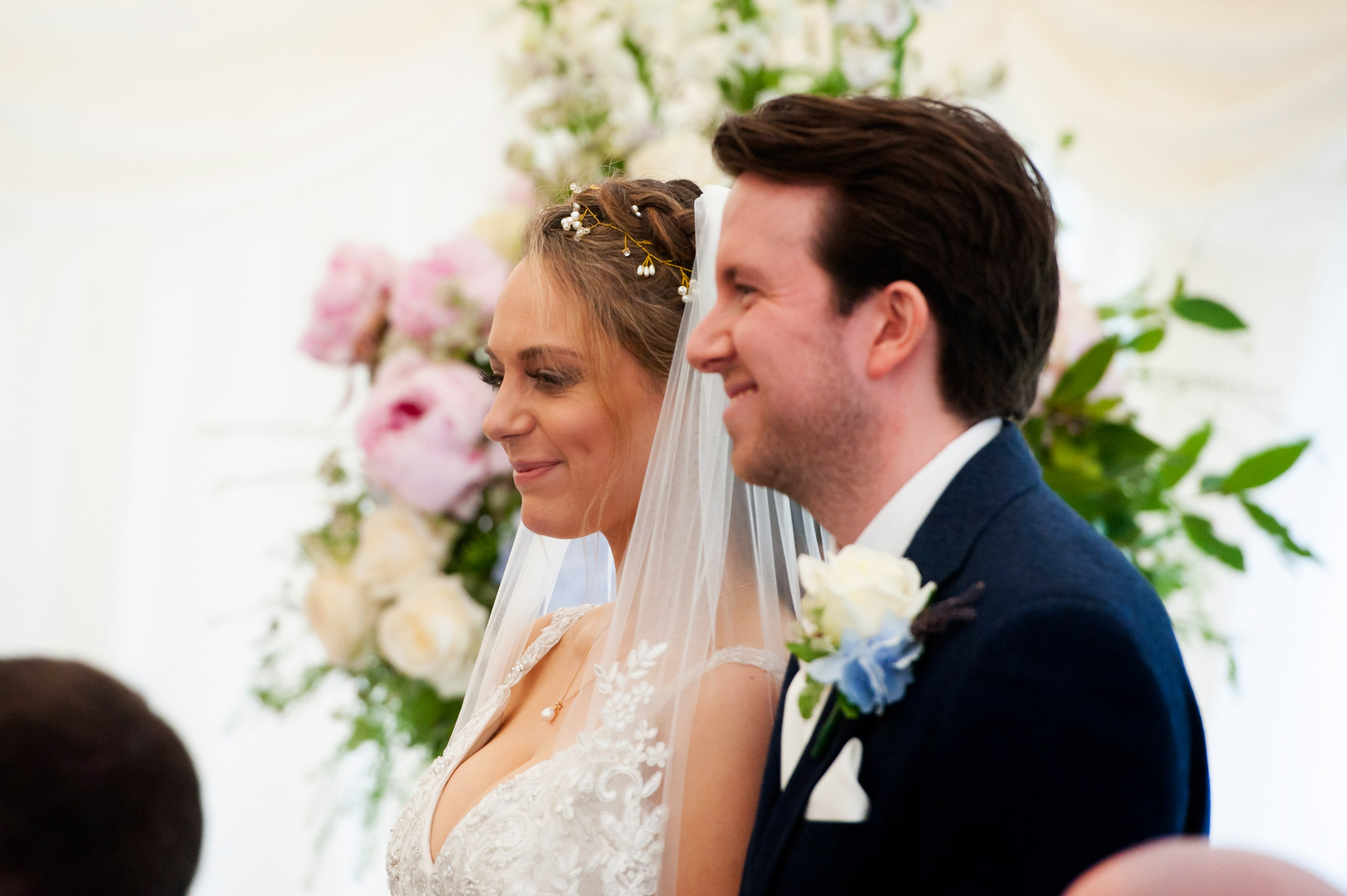 Bride and groom in profile during ceremony. 