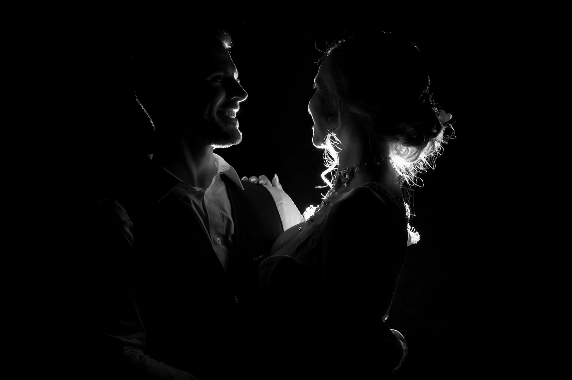 Newly married couple backlit with romantic lighting