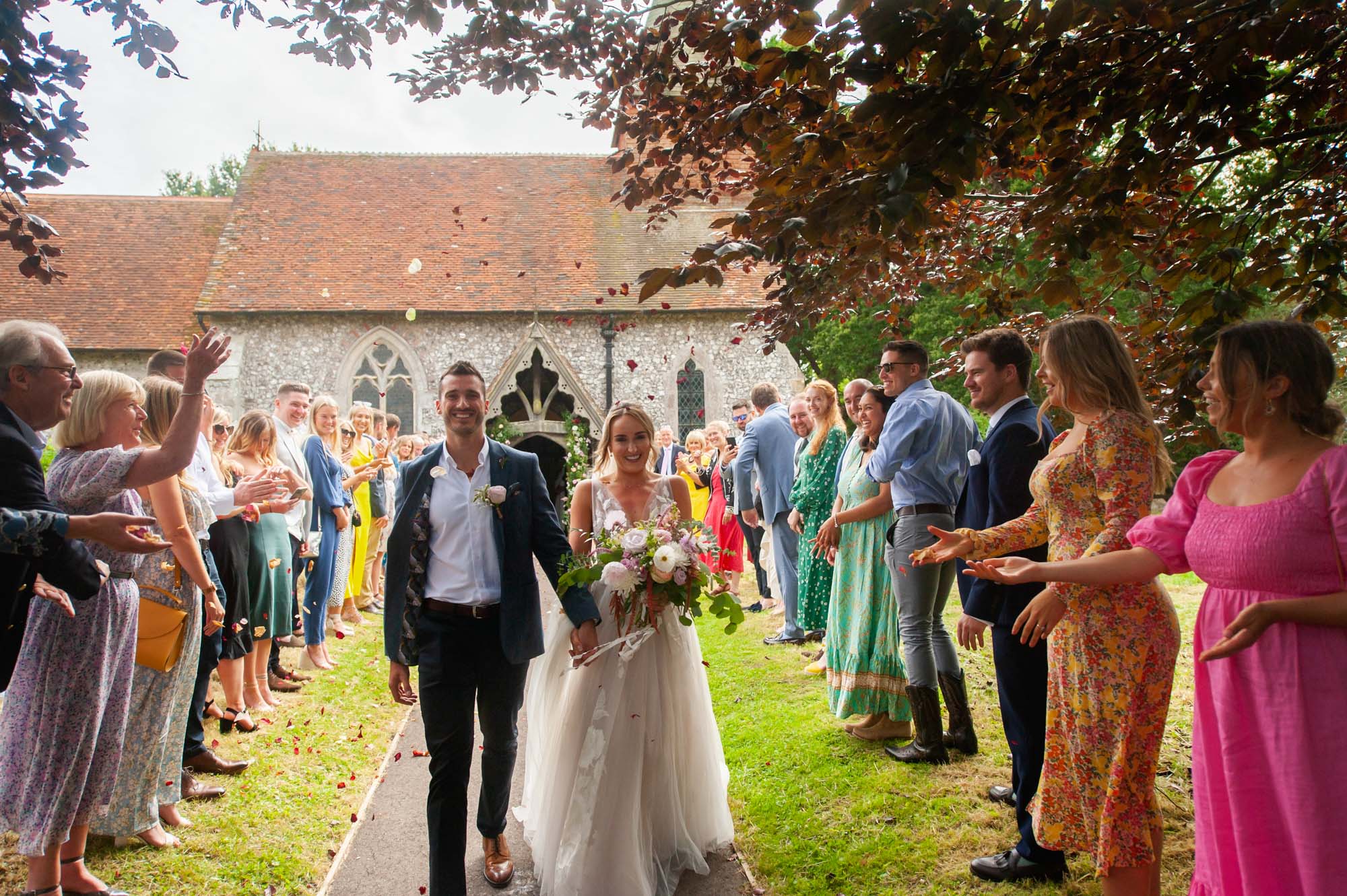 Bride and grrom with confetti at Selmeston Church.