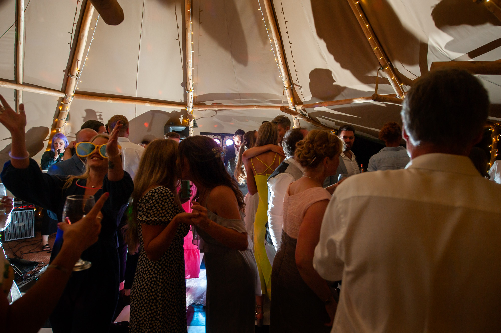 Wedding guests dancing in marquee.