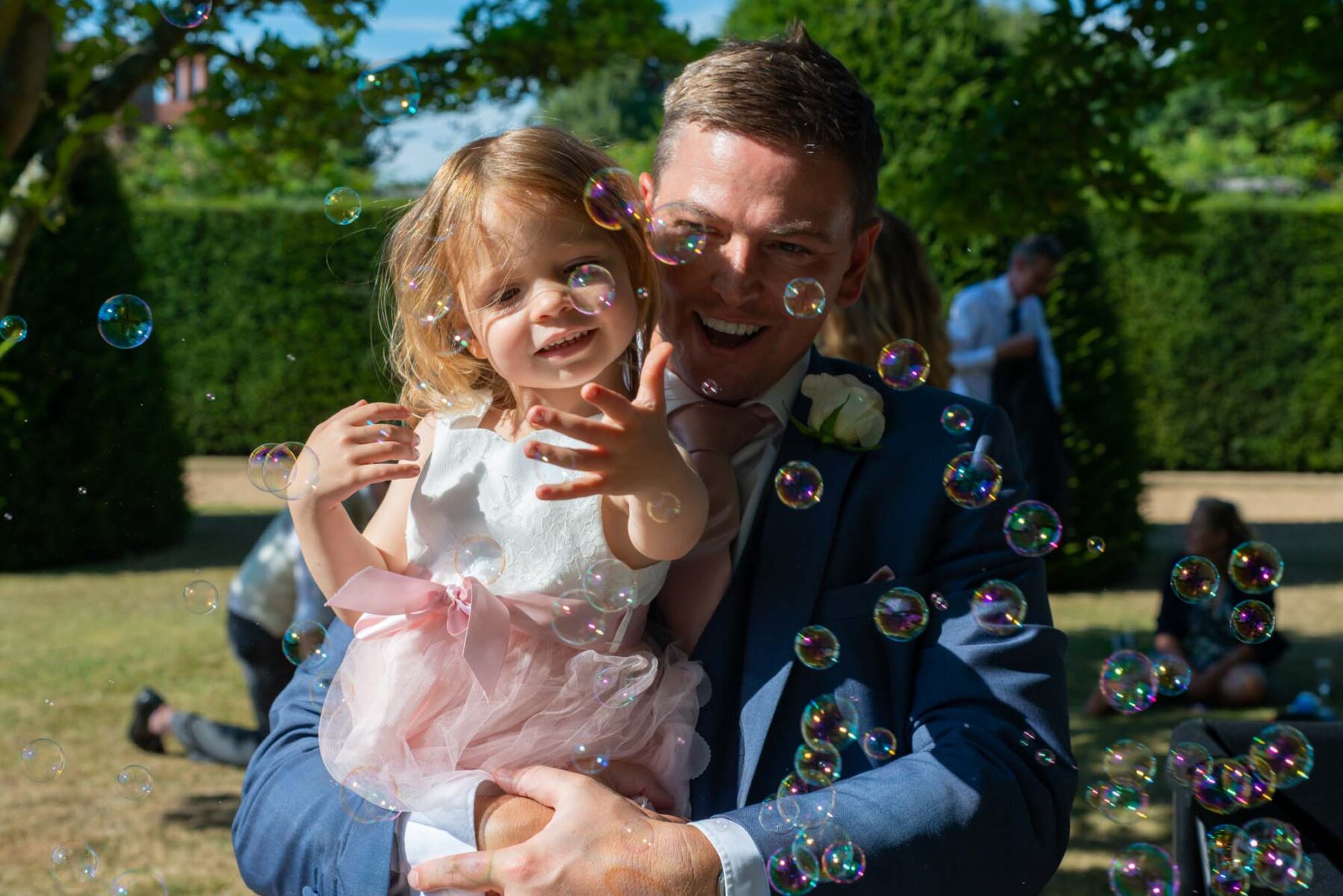 Child playing with bubbles at wedding reception 