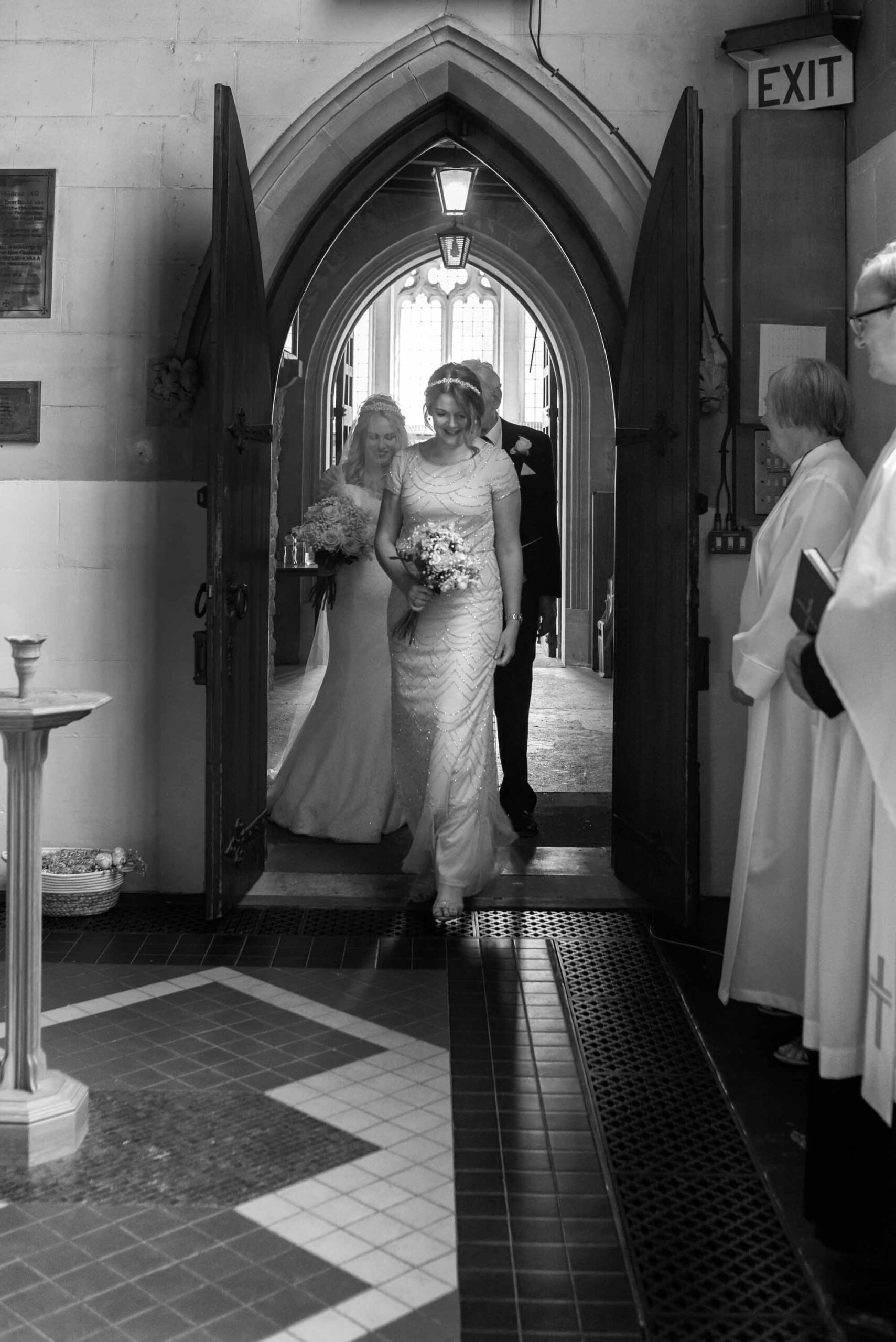 Bridal party walking into St Mary's Church Weybridge