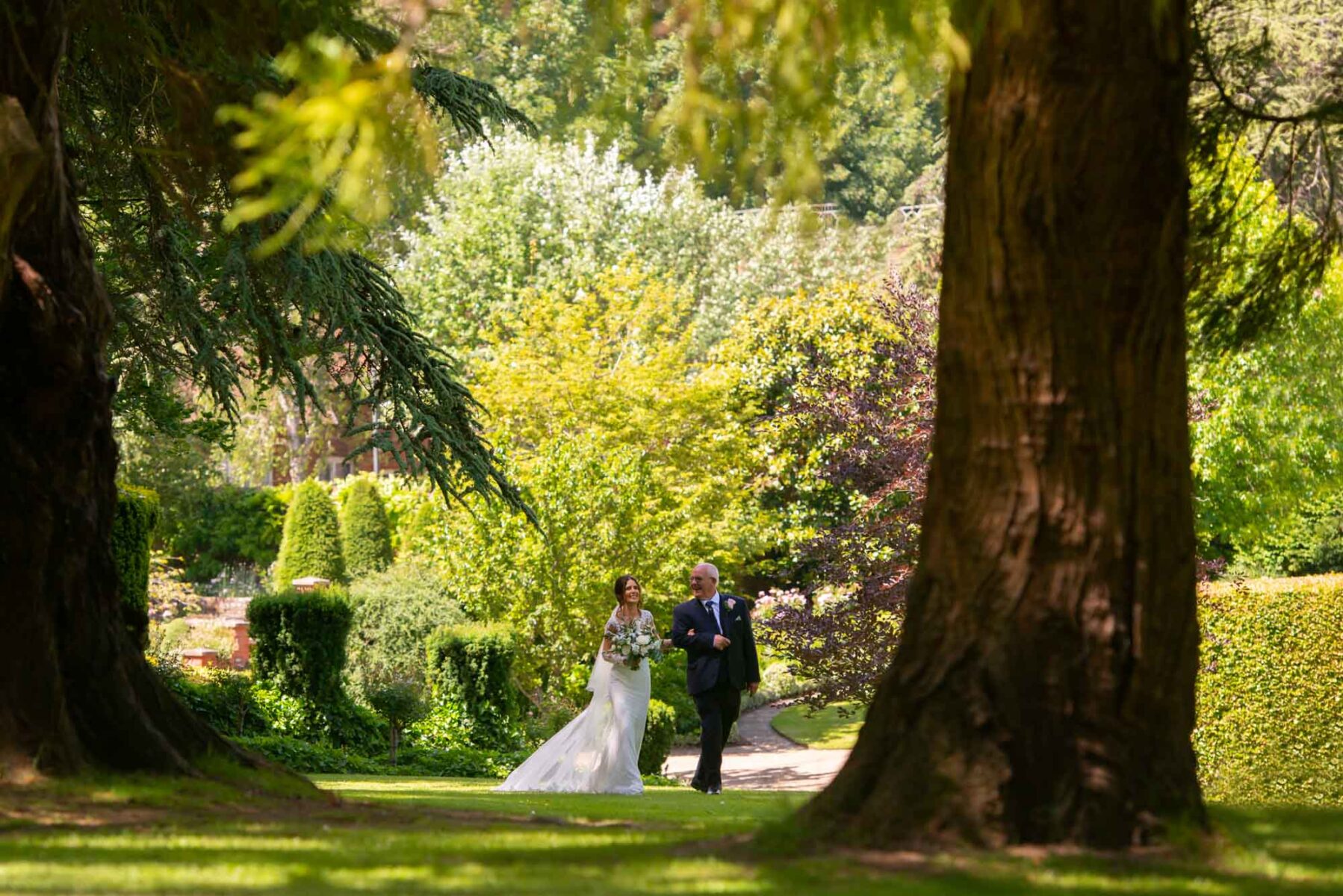 Bride and father walking to wedding ceremony at the Orangery, Maistone