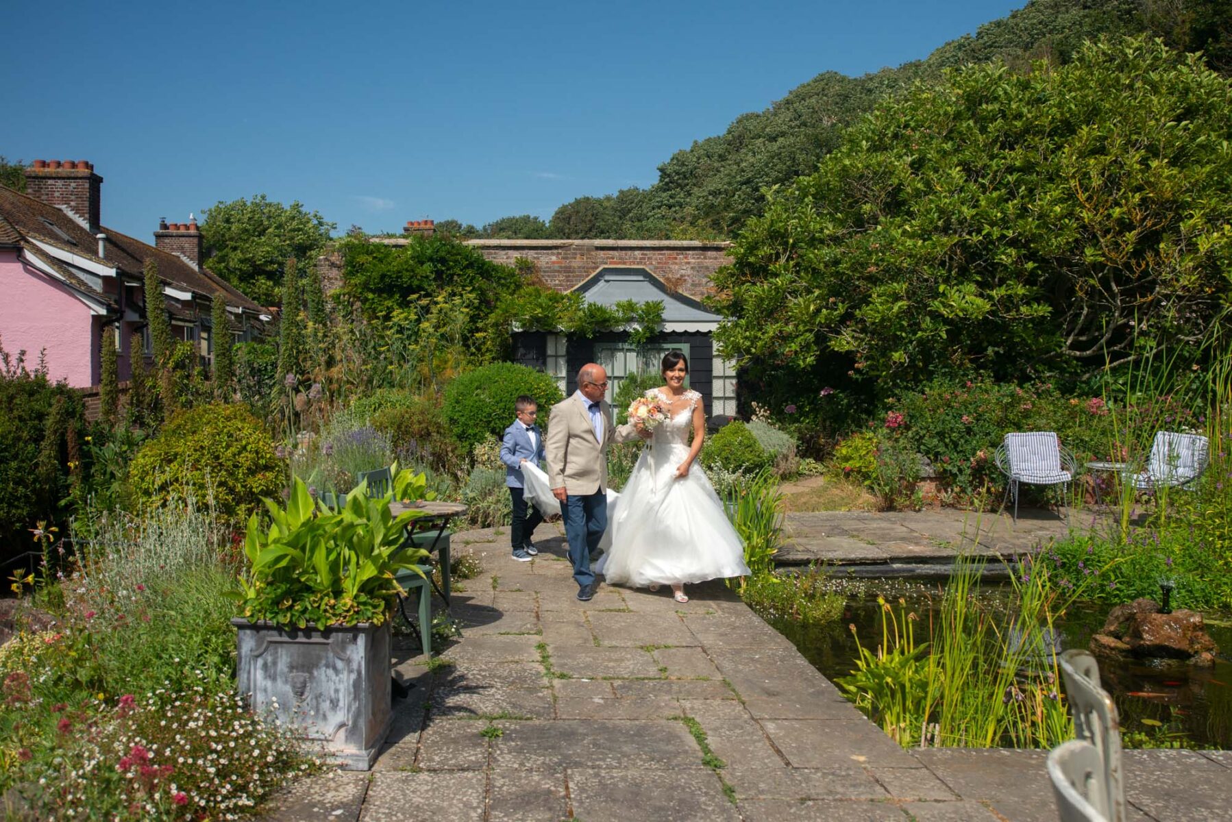 Bride and father walking through garden at the Old Rectory Hastings
